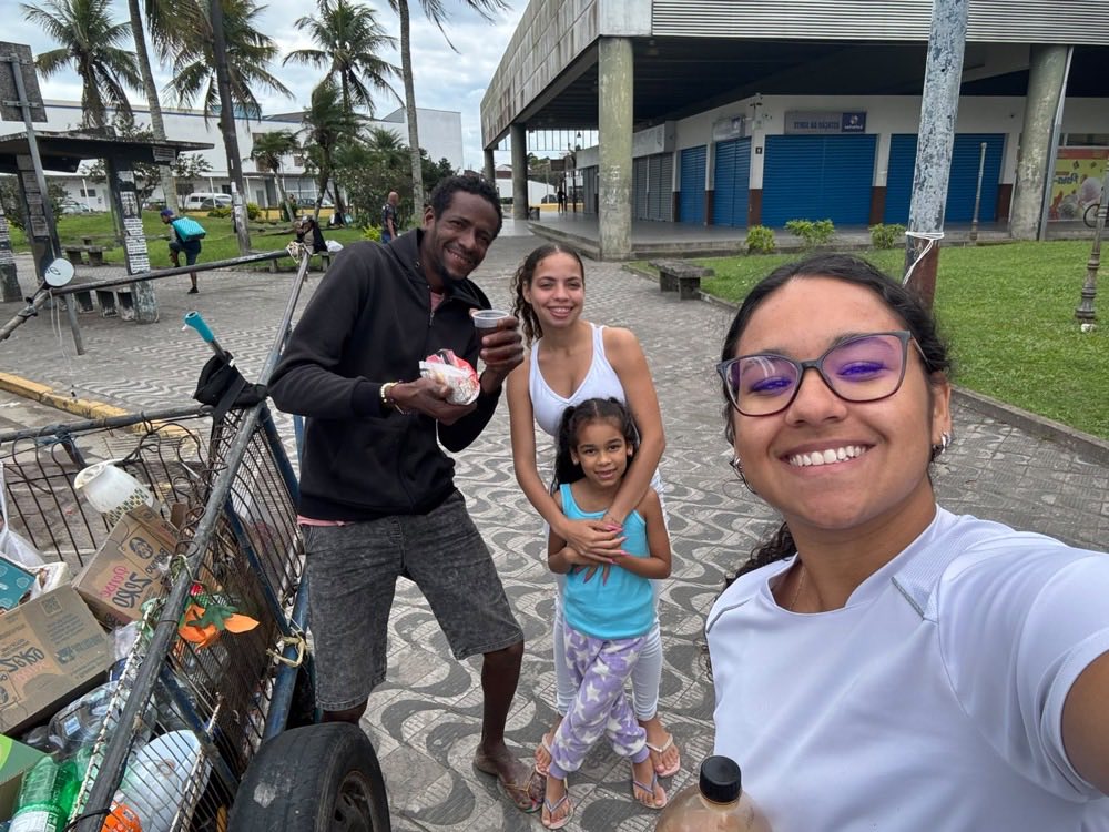 Selfie com um homem que segura lanche e refrigerante, ao lado de uma moça e uma menina