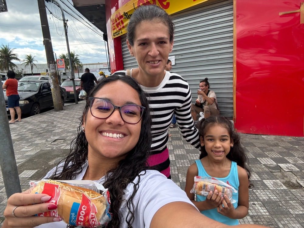 Selfie com uma mulher e uma menina, cada uma segurando um lanche